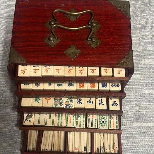 Mahjong-Steine aus Elfenbein, die in den 1870er Jahren gefunden wurden und ähnliche Symbole wie moderne Mahjong-Steine haben. Mahjong-Steine aus Elfenbein, die in den 1870er Jahren gefunden wurden und ähnliche Symbole wie moderne Mahjong-Steine haben.
